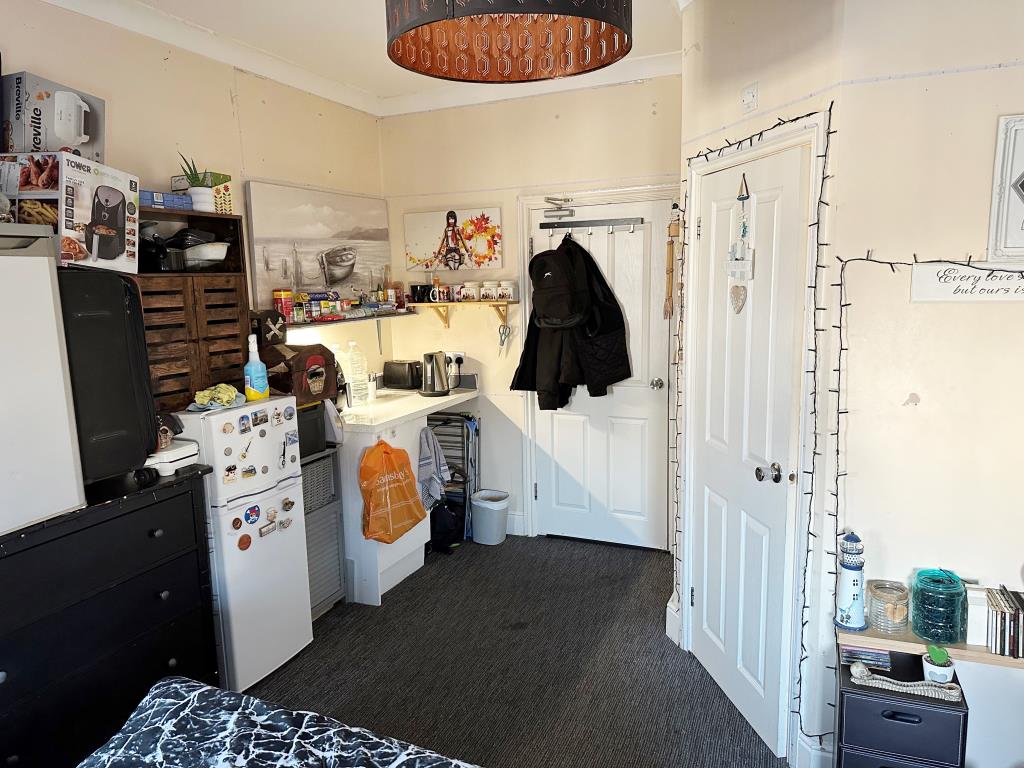 Lot: 91 - SIX-BEDROOM SEMI-DETACHED HOUSE CURRENTLY ARRANGED AS A HMO - Room showing a kitchenette in the corner